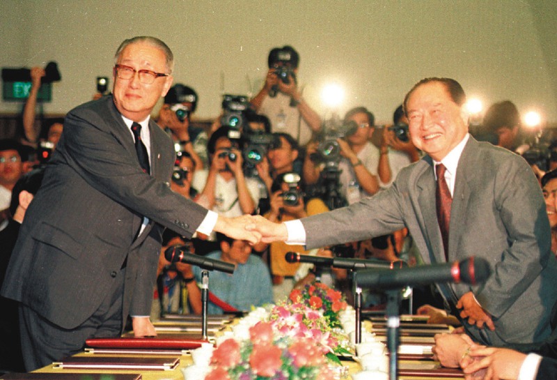 1993年，海基會董事長辜振甫（左），與海協會會長汪道涵（右）在新加坡舉行歷史性辜汪會談，會談開始前，兩人親切握手，開啟兩岸兩會溝通協商新頁。圖／聯合報系資料照片