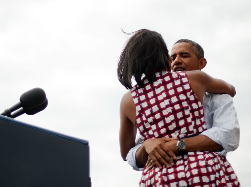 美國前總統歐巴馬（右）2012年8月15日在愛荷華州一場競選演說後，與妻子蜜雪兒擁抱。法新社