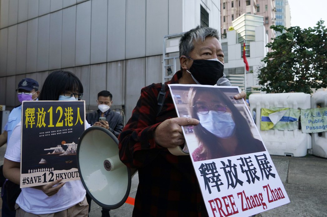 張展被判刑當天，香港市民支援愛國民主運動聯合會主席李卓人在中聯辦前抗議，要求釋放張展。 圖／美聯社