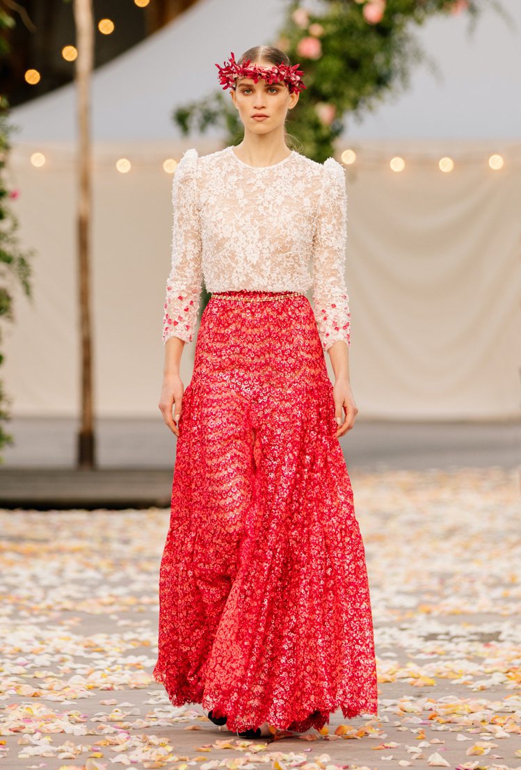 細緻的蕾絲刺繡上衣在袖口處用了紅、粉色的花朵亮片點綴，延續同樣元素的長裙所呈現的浪漫柔美。圖／香奈兒提供