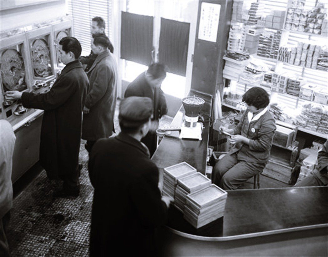 1955年東京的柏青哥店，在櫃台後面已可以看到兌換獎品提供香菸。香菸的出限，是柏...