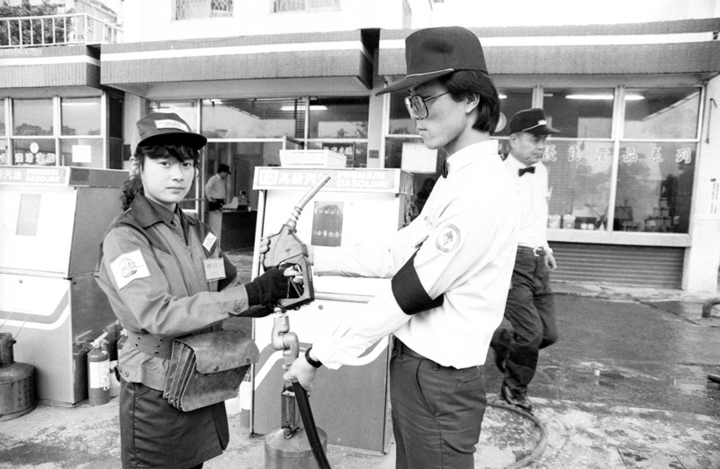 我國第一間民營加油站正式營業，西歐加油站人員（左）從中油人員（右）手中接過加油槍後正式開業。圖／聯合報系資料照片