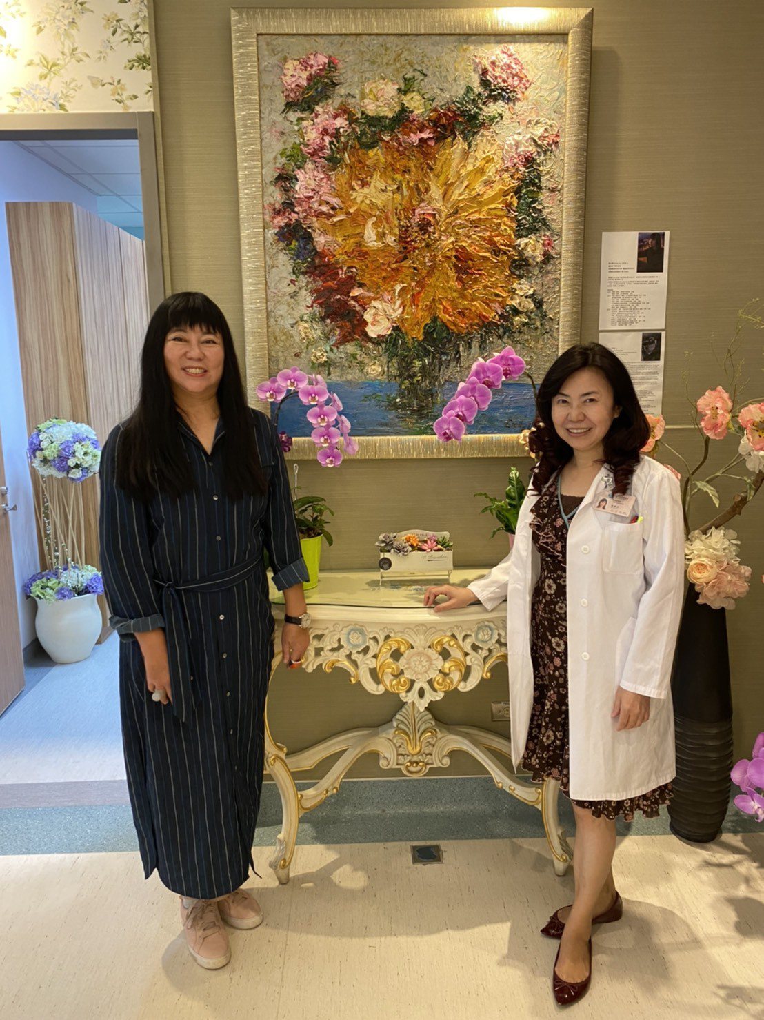 陳惠鈴(右)與畫家劉白雪在中榮植牙中心她的畫作前合影。圖／陳惠鈴提供