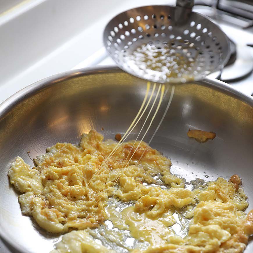 熱油鍋，取一有洞的勺子，將蛋液從上方分次倒下，並翻攪煎至飄出蛋香。 圖／阿春 攝...