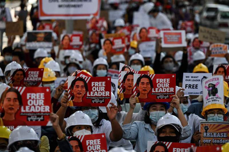 緬甸仰光的示威者10日高舉翁山蘇姬的看板要求軍方放人。 法新社