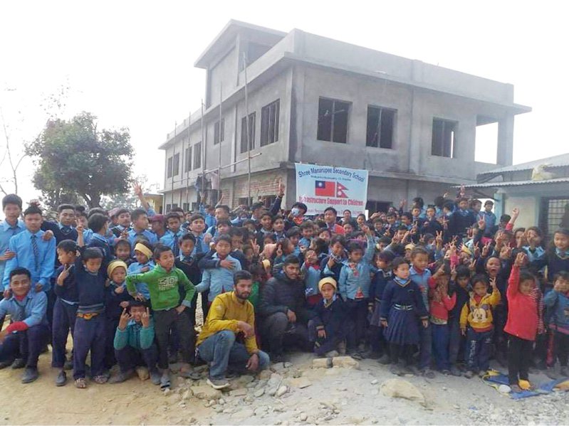 胡榮華集資在尼泊爾蓋6間教室即將完成，春節時孩子將國旗 圖繪在即將完工教室祝賀洋溢喜悅、感恩。圖／胡榮華提供