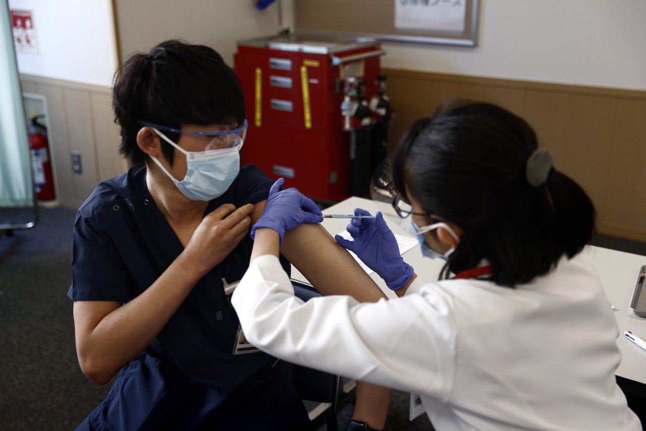 圖為日本醫護人員在日本東京接種疫苗示意圖，非新聞當事人。