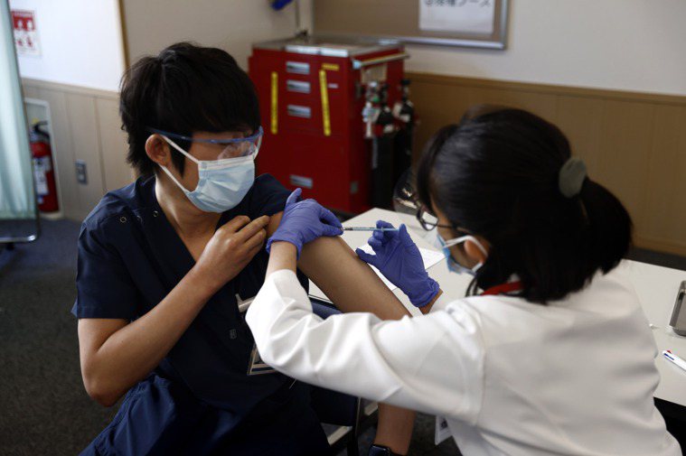 圖為日本醫護人員在日本東京接種疫苗示意圖，非新聞當事人。 新華社