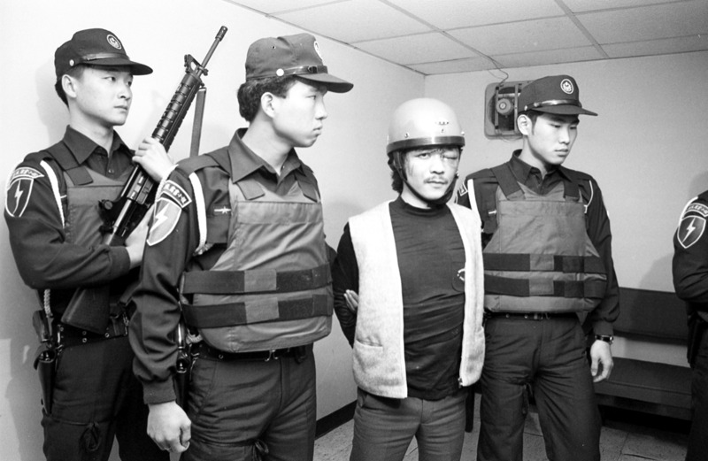 中華航空公司一架台北飛往高雄的國內線班機發生劫機事件，涉嫌劫機往大陸未遂的嫌犯簡渠淵（右2）被押回刑事警察局接受偵訊。圖／聯合報系資料照片
