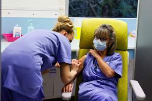 法國醫護人員接種AZ疫苗後，有很高比率出現發燒頭痛。法新社