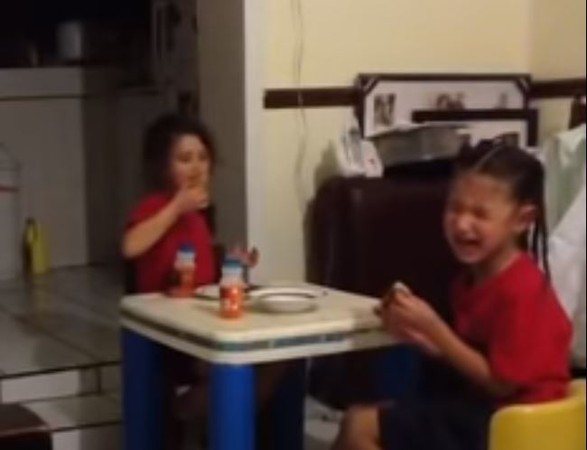 面對廚房的小女孩疑似撞鬼，嚇得大哭之際，另一人仍開心地吃著飯。 圖擷自YouTube／Angel Ruiz