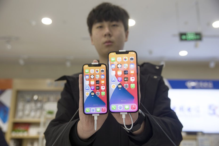 中國大陸一家商場工作人員展示蘋果iPhone 12 mini（左）和iPhone 12 Pro Max（右）手機。  中新社