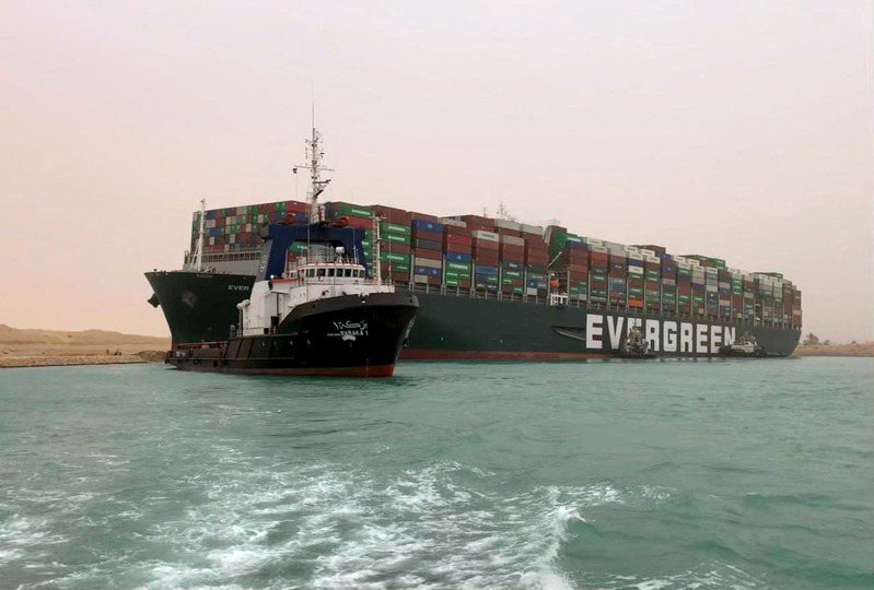 長榮海運大型貨櫃輪長賜輪（Ever Given）昨天在狹窄的蘇伊士運河（Suez Canal）轉彎時不慎擱淺，造成河道嚴重堵塞，等候通行的船隻大排長龍。 法新社
