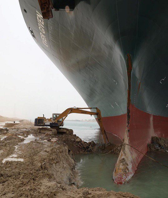 蘇伊士運河管理局3月25日發布照片，可見怪手正狂挖船頭周圍運河堤岸沙土。路透