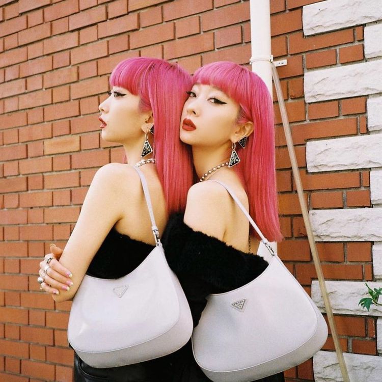 日本鈴木雙胞胎姊妹花Aya及Ami配戴PRADA垂墜式三角Logo耳環。圖／摘自IG