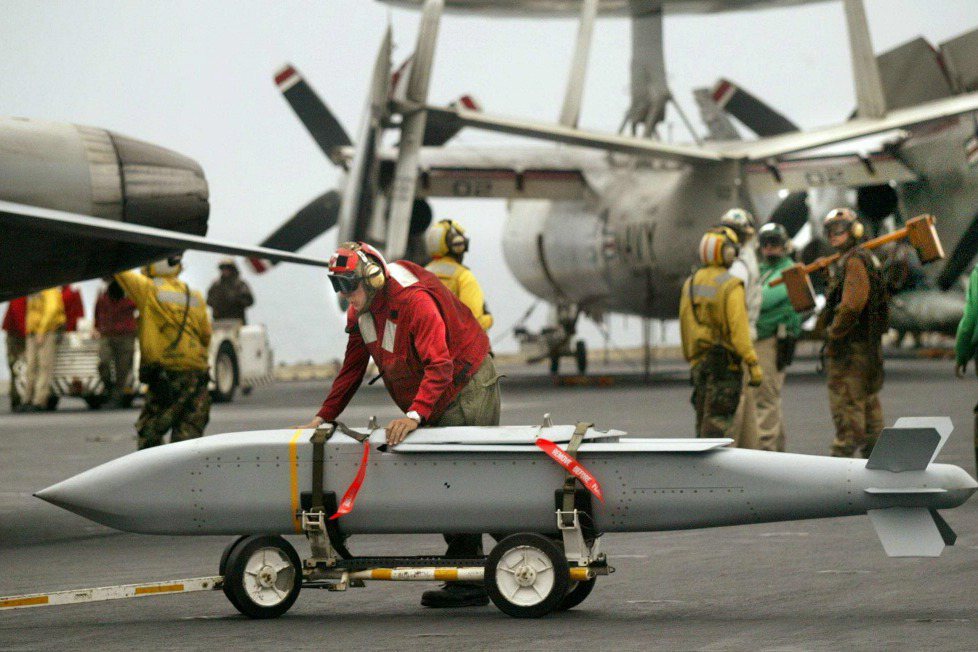 2003年，一名美國海軍正在搬運聯合距外精準武器。 圖／法新社