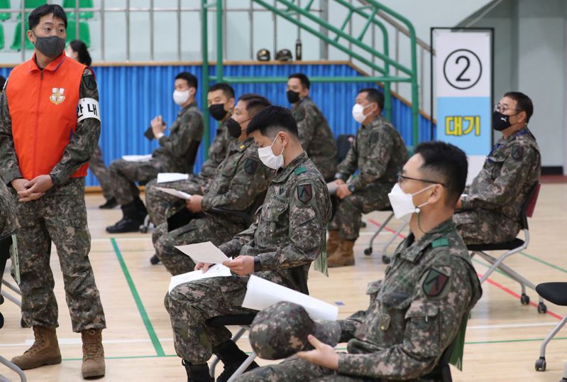 南韓男性滿19歲以後必須入伍服役。圖為南韓軍人等待接種新冠肺炎疫苗。法新社