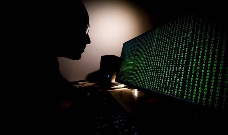 波蘭華沙一名男子看著顯示二進位代碼的電腦螢幕，攝於2月。紐時指「黑暗面」在網際犯罪領域算是相對新的成員，他們將服務出租給出價最高的出價者，還「跟勒贖軟體開發人員分享利益」。路透/Sipa USA