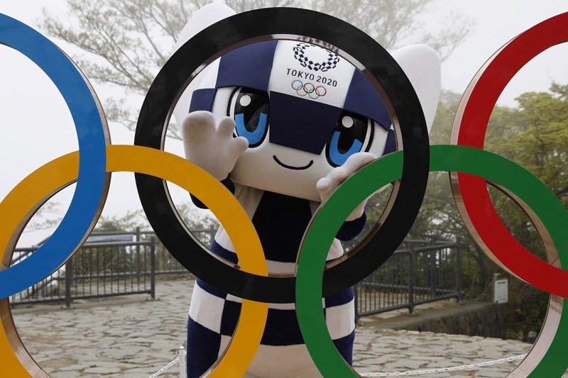 日本東京奧運吉祥物未來永遠郎4月14日站在東京都八王子市高尾山的奧運五環後供媒體拍照。距東奧正式開鑼只剩不到70天，輿論、地方政府與醫界的反對聲浪正日益高漲。美聯社