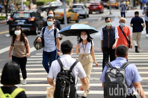 疫情警戒後升級，民眾上班途中就算在室外也全程戴著口罩。 圖／記者林伯東攝影