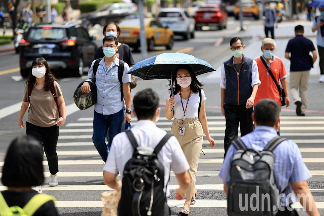 疫情警戒後升級，民眾上班途中就算在室外也全程戴著口罩。 圖／記者林伯東攝影