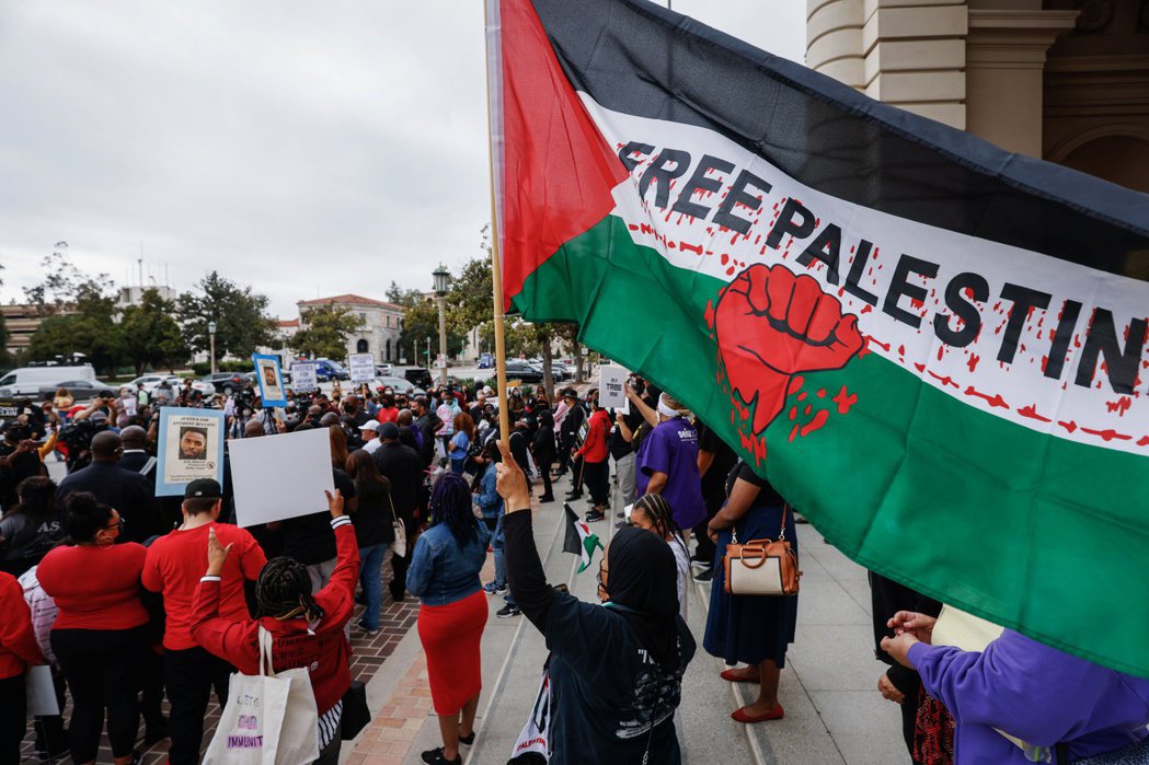 以色列與巴勒斯坦近期再度於加薩走廊走火，民眾於遊行時揮舞巴勒斯坦旗幟。 路透