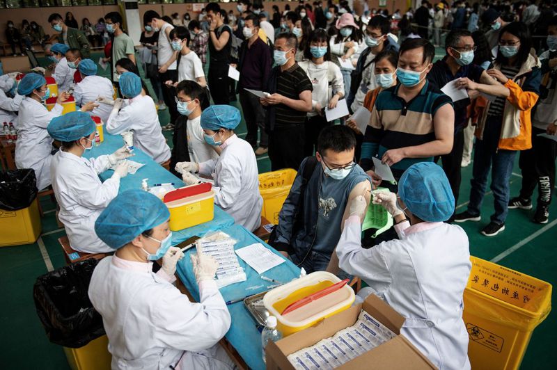 新冠病毒已在全球造成347萬多人死亡。圖為武漢一所大學上月28日給學生接種中國生物技術公司研發的新冠疫苗。法新社