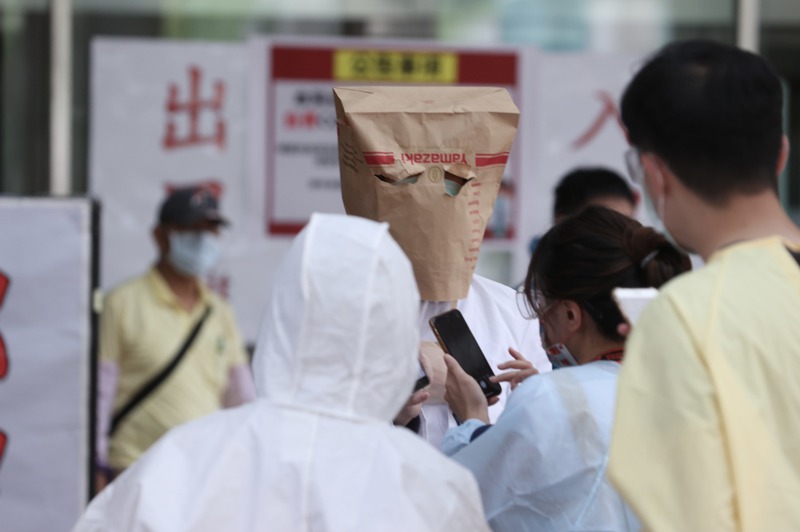 台北市醫師職業工會日前要求雙北醫院應全面暫停醫學生到院實習，避免增加感染風險。圖為醫學生前往醫院時以紙袋罩頭出現。圖／聯合報系資料照片