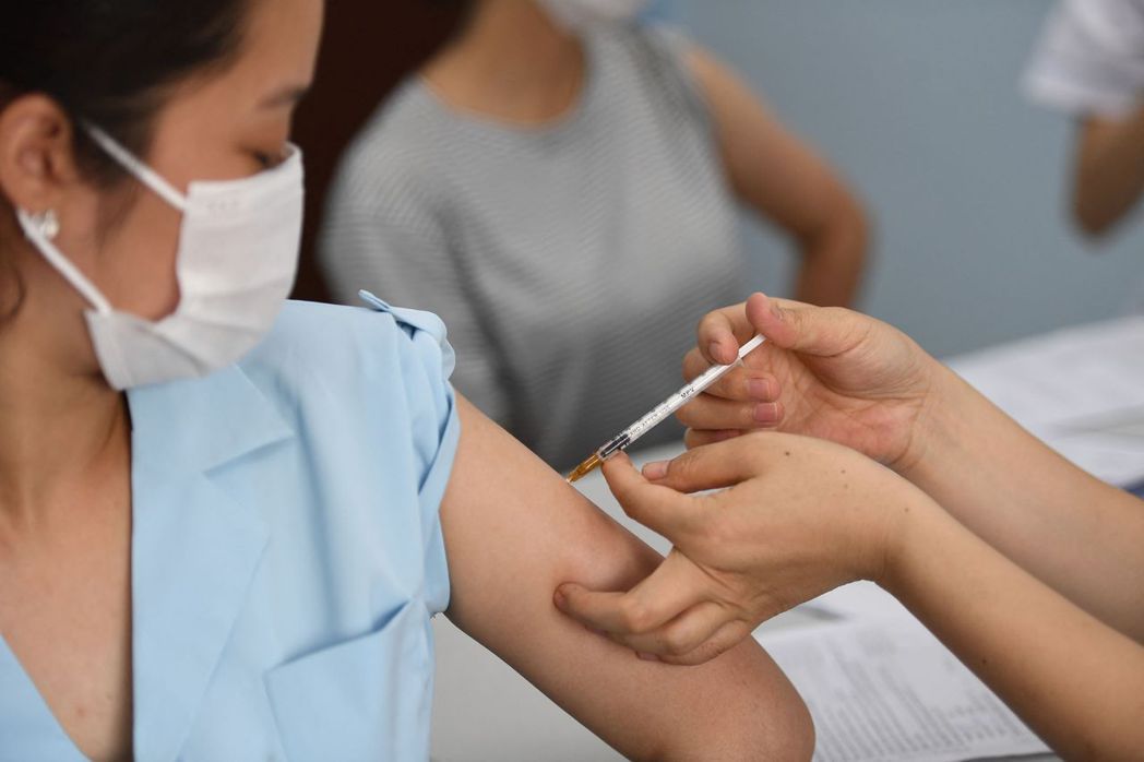 越南一名女子上月十七日在河內白梅醫院接種第一劑阿斯特捷利康（AZ）疫苗。（法新社...