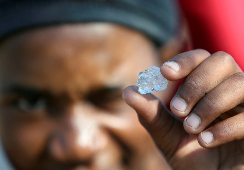 一名南非男性展示挖到的戰利品。儘管當地政府警告這些石頭可能一文不值，但仍澆不熄民眾的「鑽石狂熱」。路透