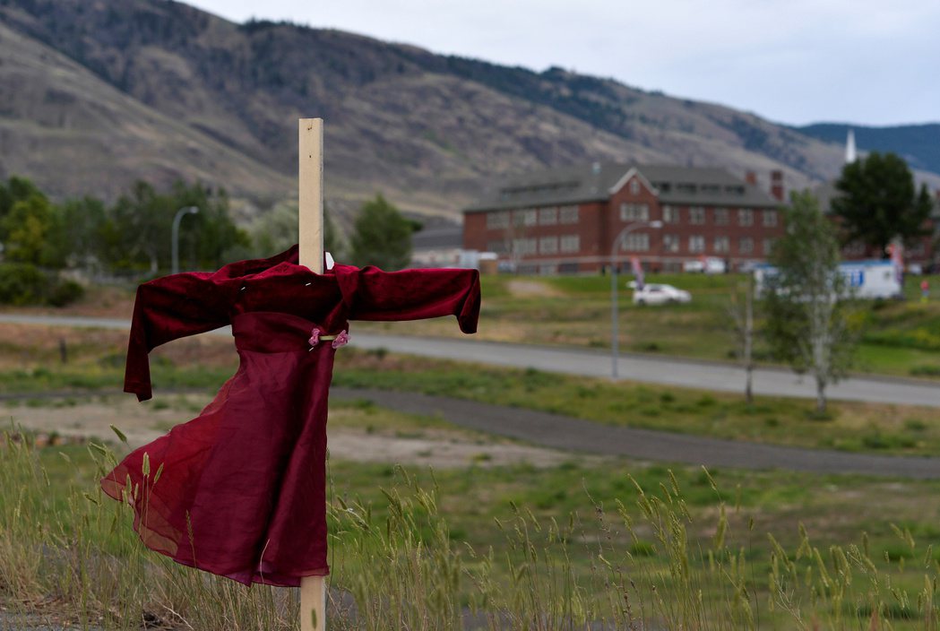 圖為在坎盧普斯學校附近，紀念者架起的十字架、並掛著象徵小女孩的紅色兒童洋裝。 圖...