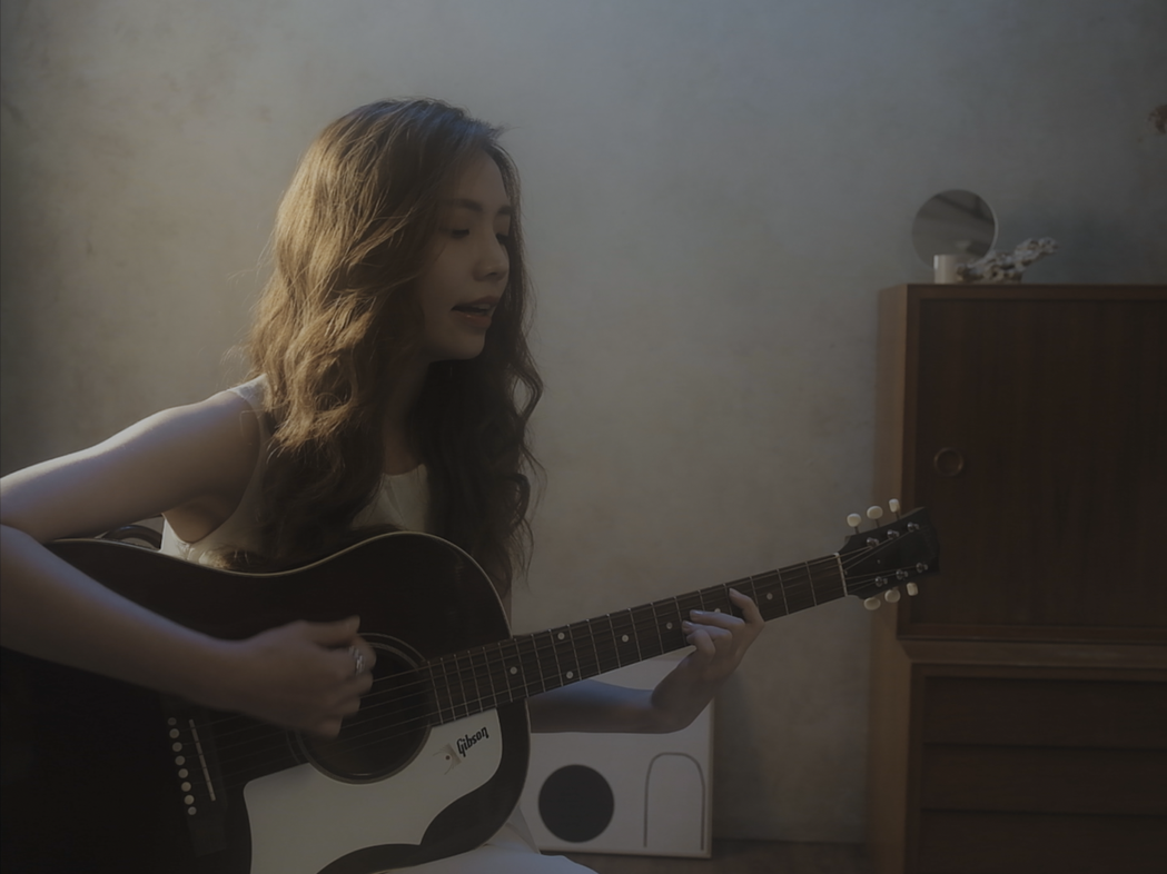 June Pan在MV中拿起木吉他自彈自唱。圖／June Pan提供