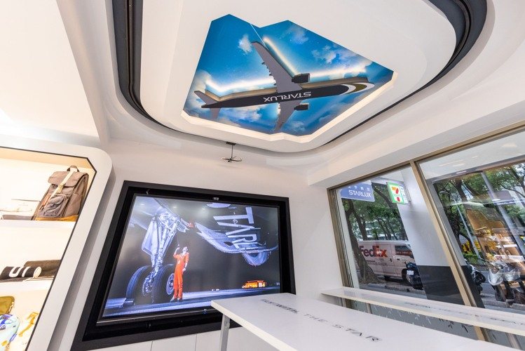 「7-ELEVEN X 星宇航空主題店」休憩區天花板打造立體裁型飛機燈板，搭配可隨燈光變換白天黑夜的天空背景，外圍還有飛機模型環繞著軌道運行。圖／7-ELEVEN提供