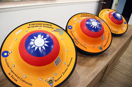 中央大學地球科學院將自行研發、8顆印有中華民國國旗的微型海洋浮球，運往北極測站，展開台灣前所未有的第一手觀測。圖／中央大學提供