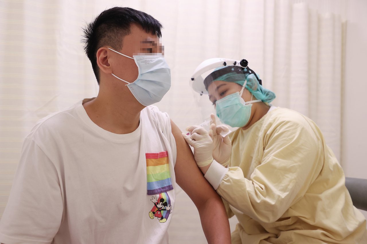 圖為25日亞東醫院為年輕人施打疫苗殘劑。