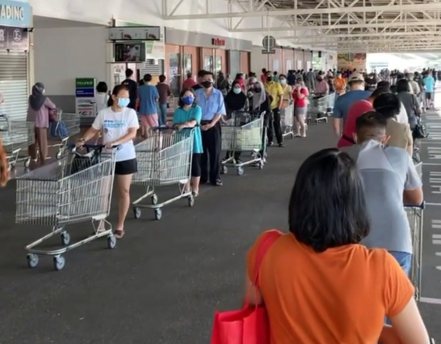 馬來西亞宣布全國封城後，超市出現大量排隊搶購人潮。(路透)
