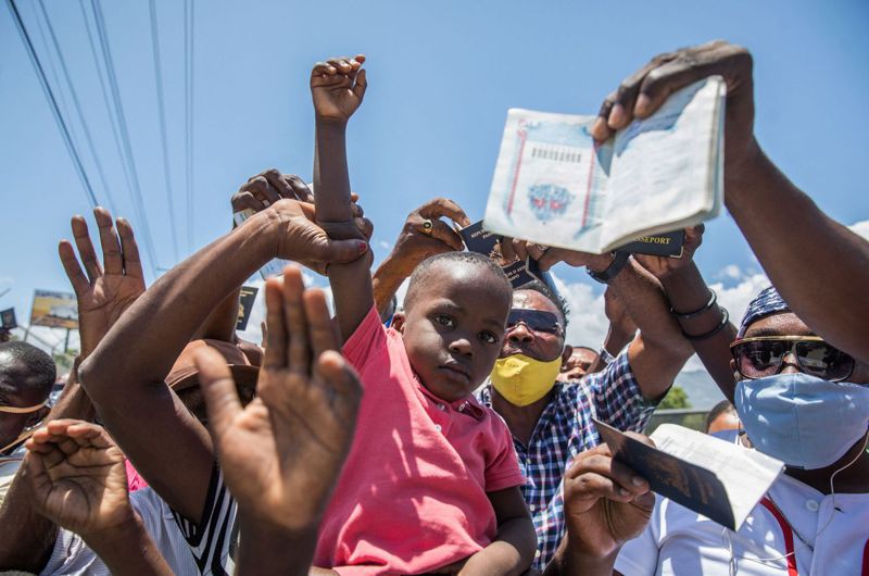 海地人民十日在美国大使馆前手持护照要求政治庇护，因为在海地生命财产没保障。（法新社）(photo:UDN)