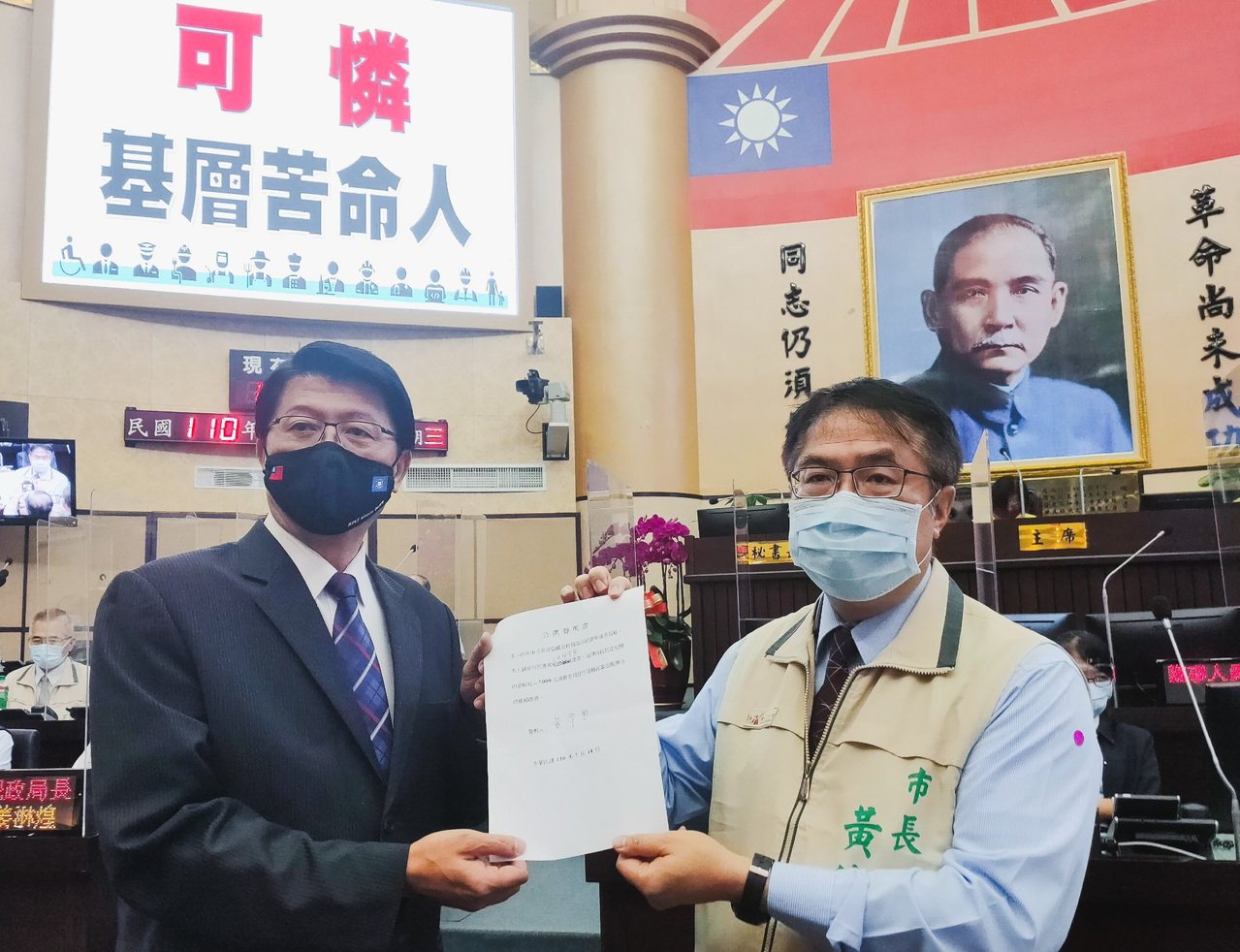 國民黨台南市議員謝龍介（左）建議台南市長黃偉哲（右）向中央提案在短期內發放每人5千元消費券，振興基層經濟，並要黃簽署承諾書。記者鄭維真／攝影
