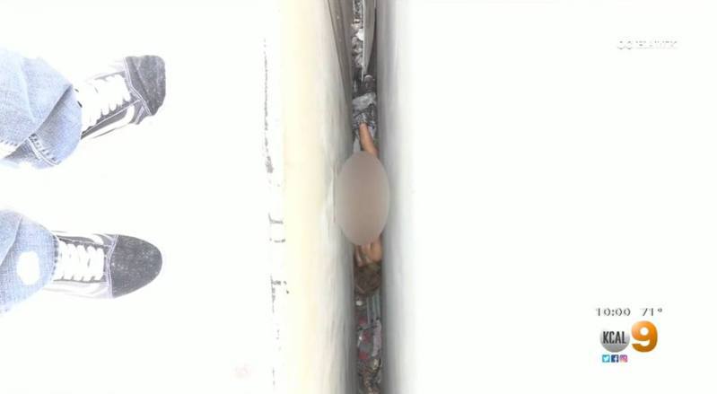 1名女子全裸卡在2大厦中间的窄缝。 图／KCAL9新闻截图(photo:UDN)