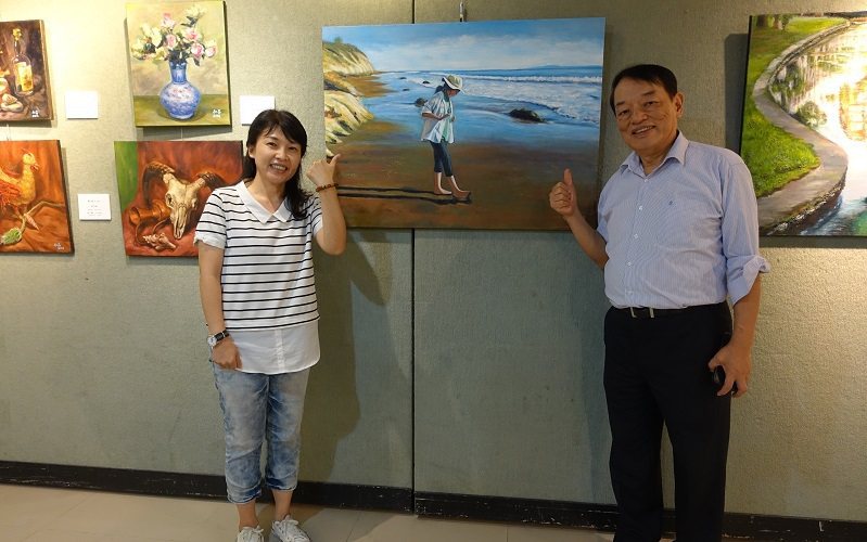 指導老師賴瑋綺（左）出席畫展，與廖仁昌（右）和《聖塔芭芭拉海灘少女》一同合照。 ...
