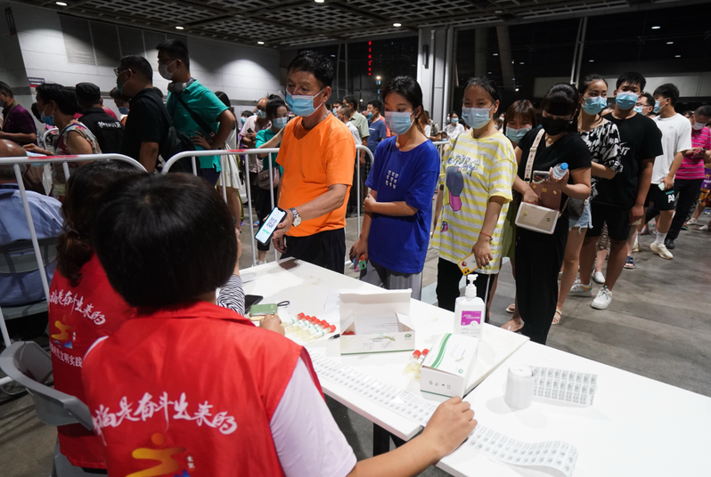 圖為南京市玄武區一處檢測點，21日晚間，市民依序排隊登記等候進行核酸檢測。新華社