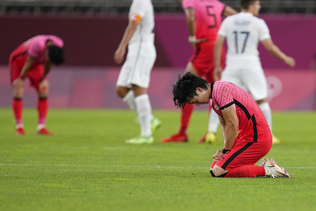 南韓暴冷不敵紐西蘭，球員失望跪坐在草地上。 美聯社