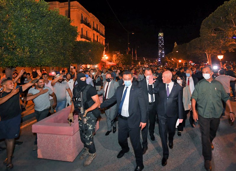 突尼西亚总统萨伊德（图穿西装挥手者）廿五日开除总理并冻结国会后，在保安人员护卫下向支持者致意。（法新社）(photo:UDN)