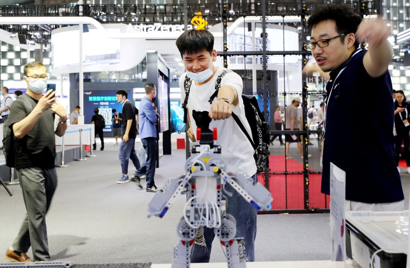 2021世界人工智能大會展覽現場，參觀者體驗體感機器人玩具。新華社
