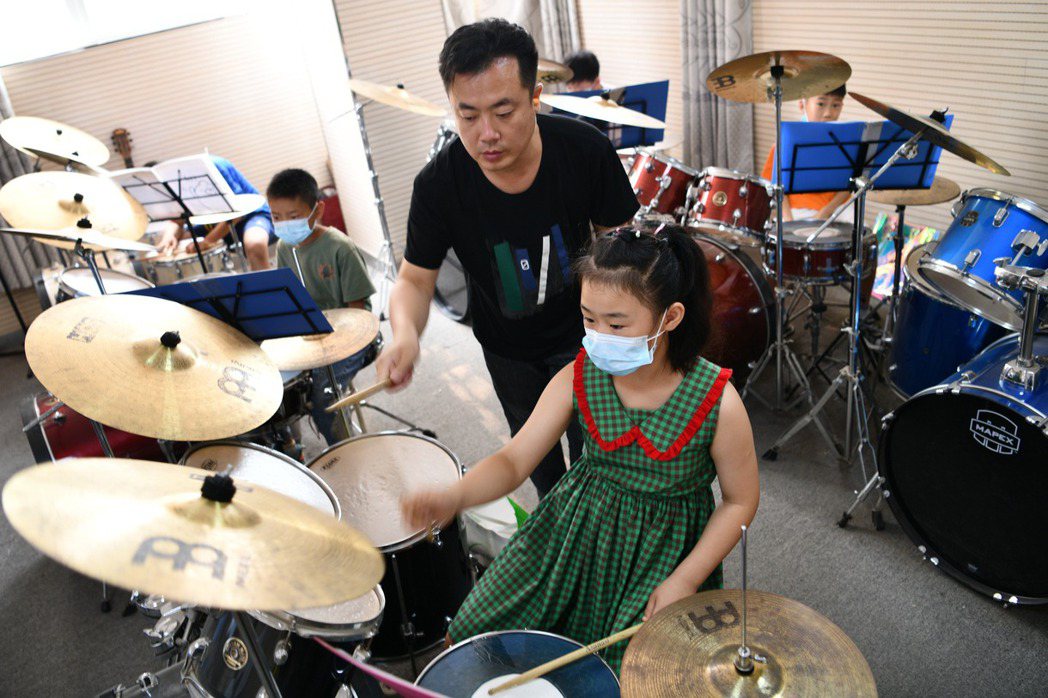 圖為中國學童在培訓機構學習爵士鼓。 圖／新華社