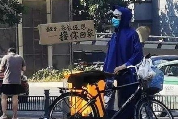 鄭州地鐵淹水事故後，一名父親穿著雨衣牽著腳踏車，在沙口路站外頭守候的身影在網上流傳。圖／取自微博