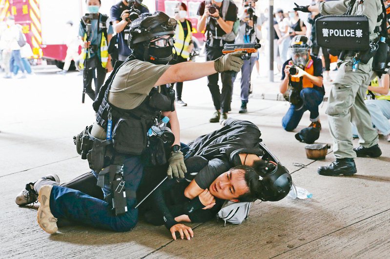 我政府有關人士指出，唐英傑案既是國安法首例，刑度如此之重，勢將讓香港陷入寒蟬效應。圖為港方壓制反對港版國安法的示威者。路透
