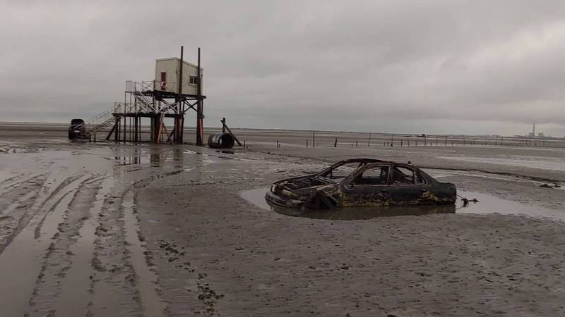 伸港海域潮間帶，多輛廢置轎車遭海水鏽蝕，隨潮起潮落隱現。圖／伸港消防分隊提供