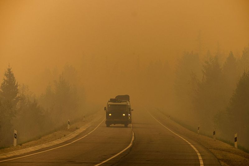 俄國西伯利亞薩哈共和國一輛車7月27日在馬加拉斯村和雅庫茨克市間行駛，沿途被野火造成的煙霧籠罩。法新社