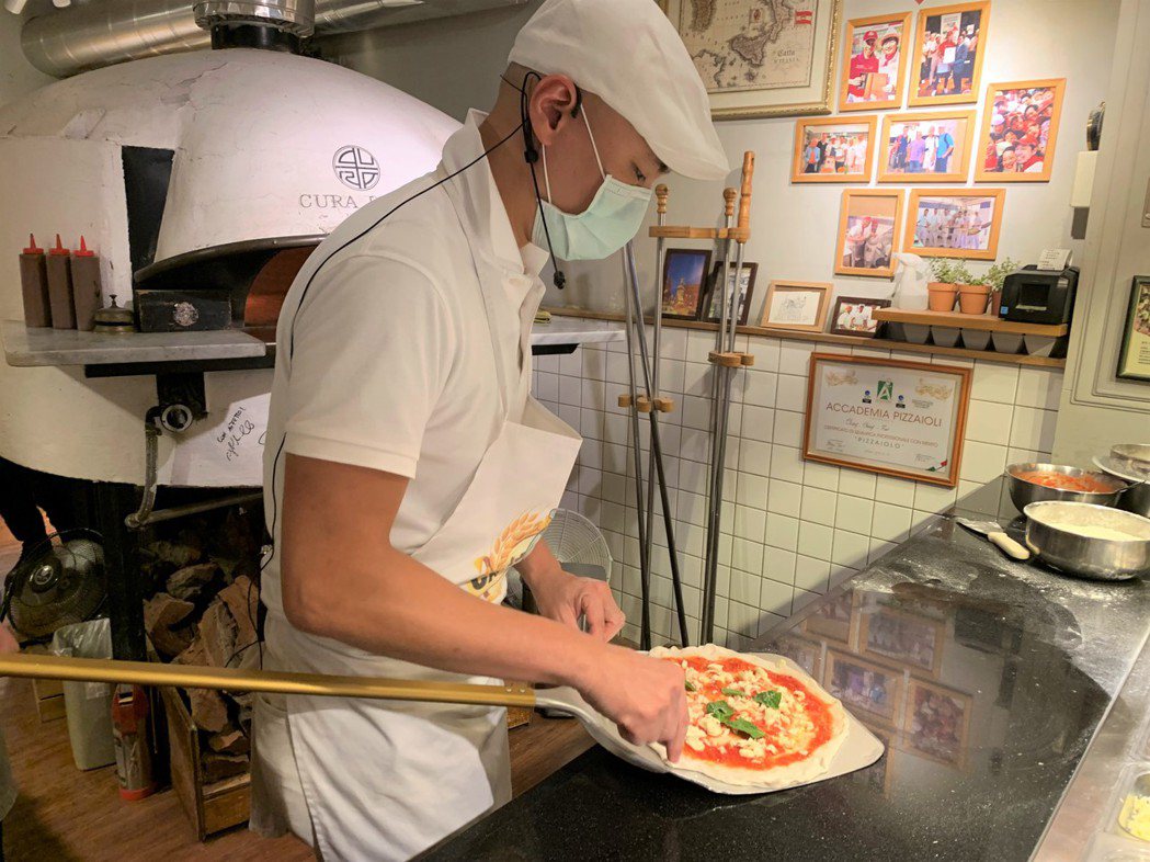 CURA PIZZA店主張中豪製作披薩全神投入、樂在其中。圖／于國華提供
